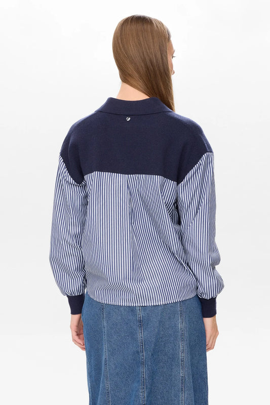Person wearing a blue and white striped shirt with navy sleeves on a white background