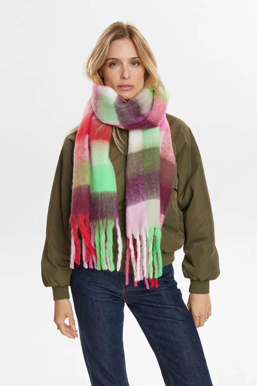 Woman wearing a colorful scarf with a plain background
