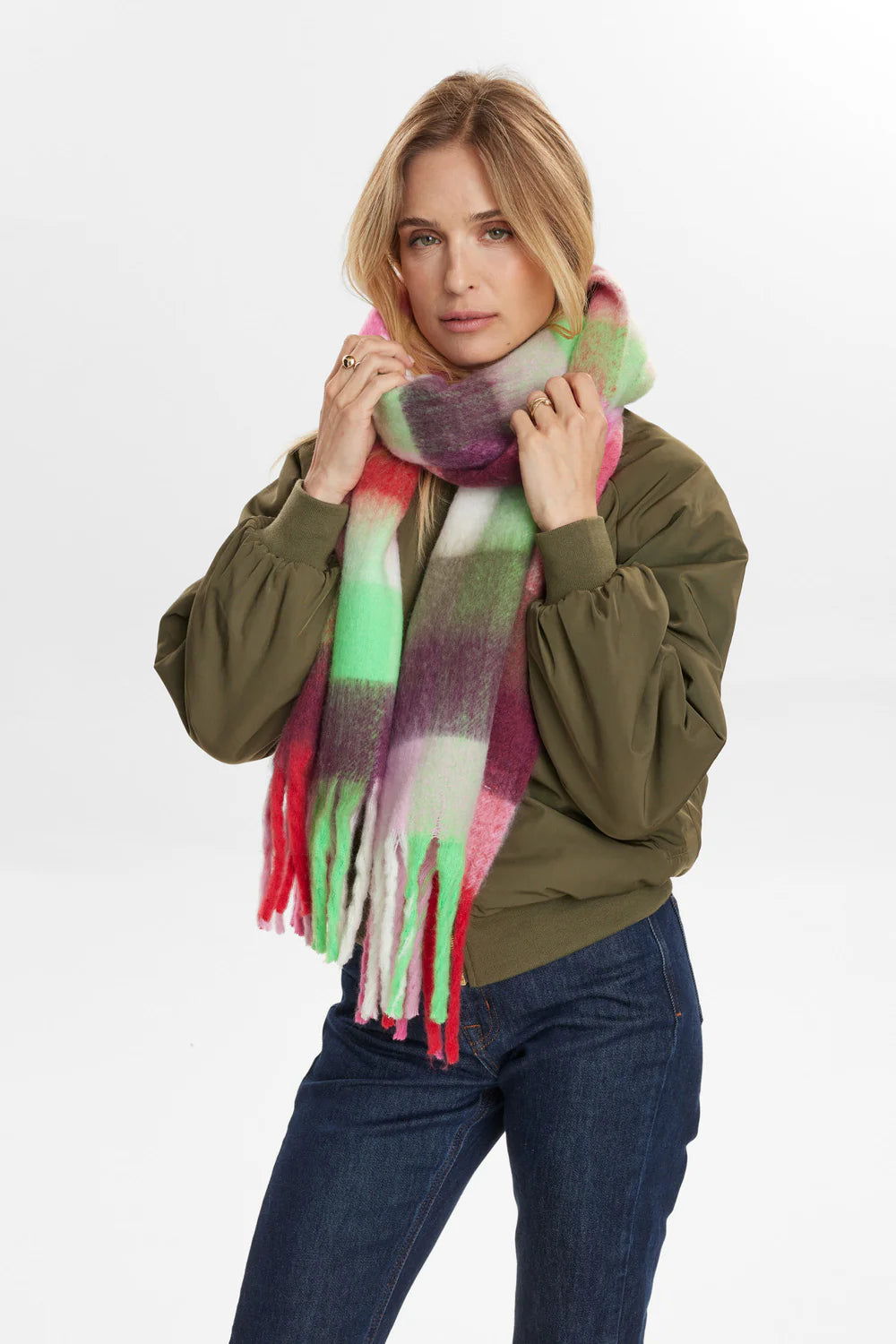 Woman wearing a colorful scarf with a plain background