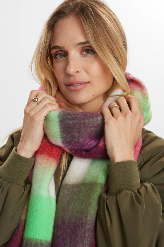 Woman wearing a colorful scarf with a neutral background