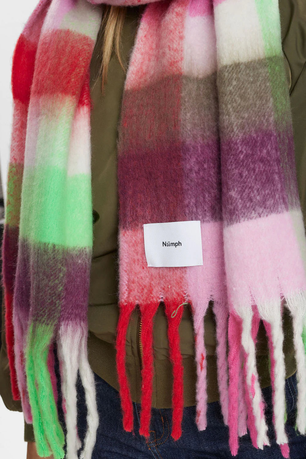 Colorful plaid scarf with a 'Ninjih' label draped over a person, on a white background.