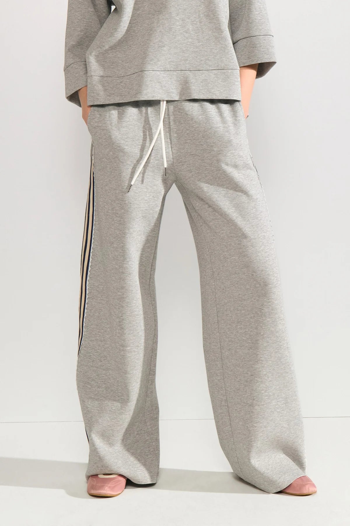 grey joggers with a black embroidered striped outer seam on a neutral background
