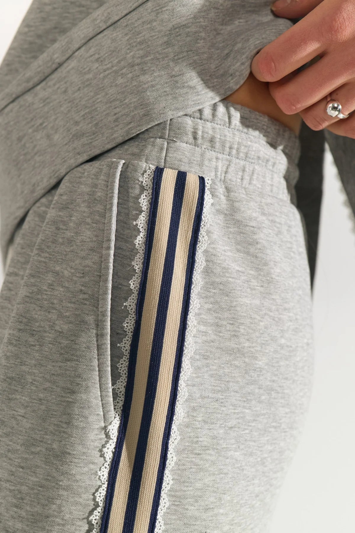 Gray sweatpants with decorative stripes on a neutral background