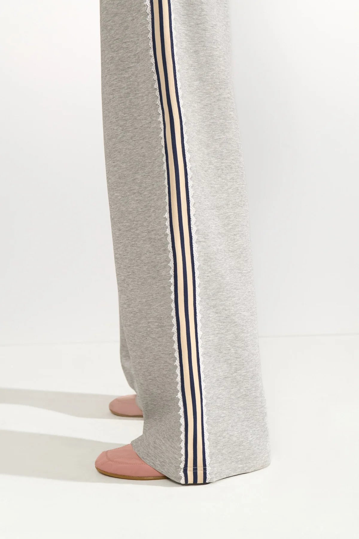 Gray sweatpants with striped side panels on a white background