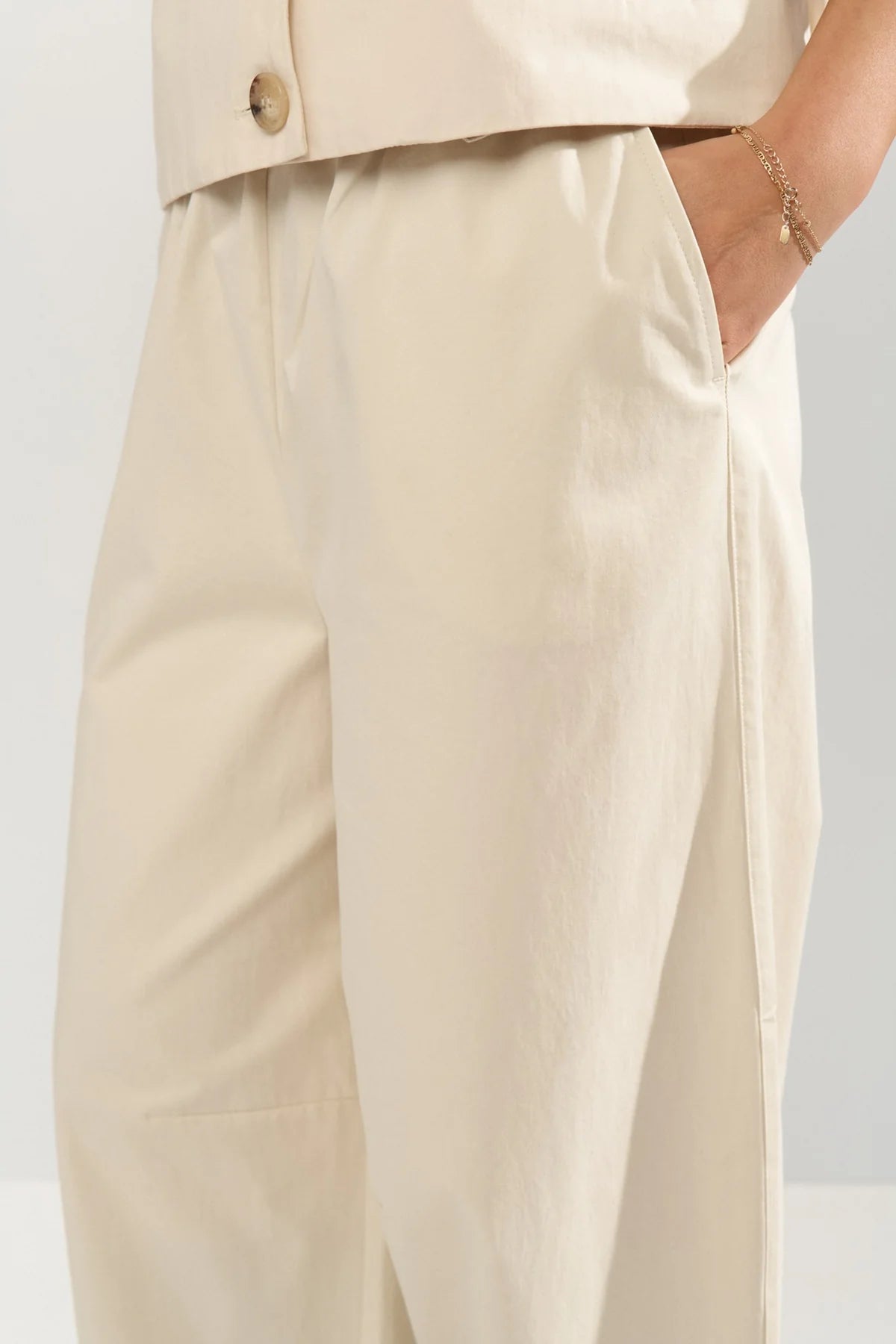 Beige pants worn by a person on a light gray background