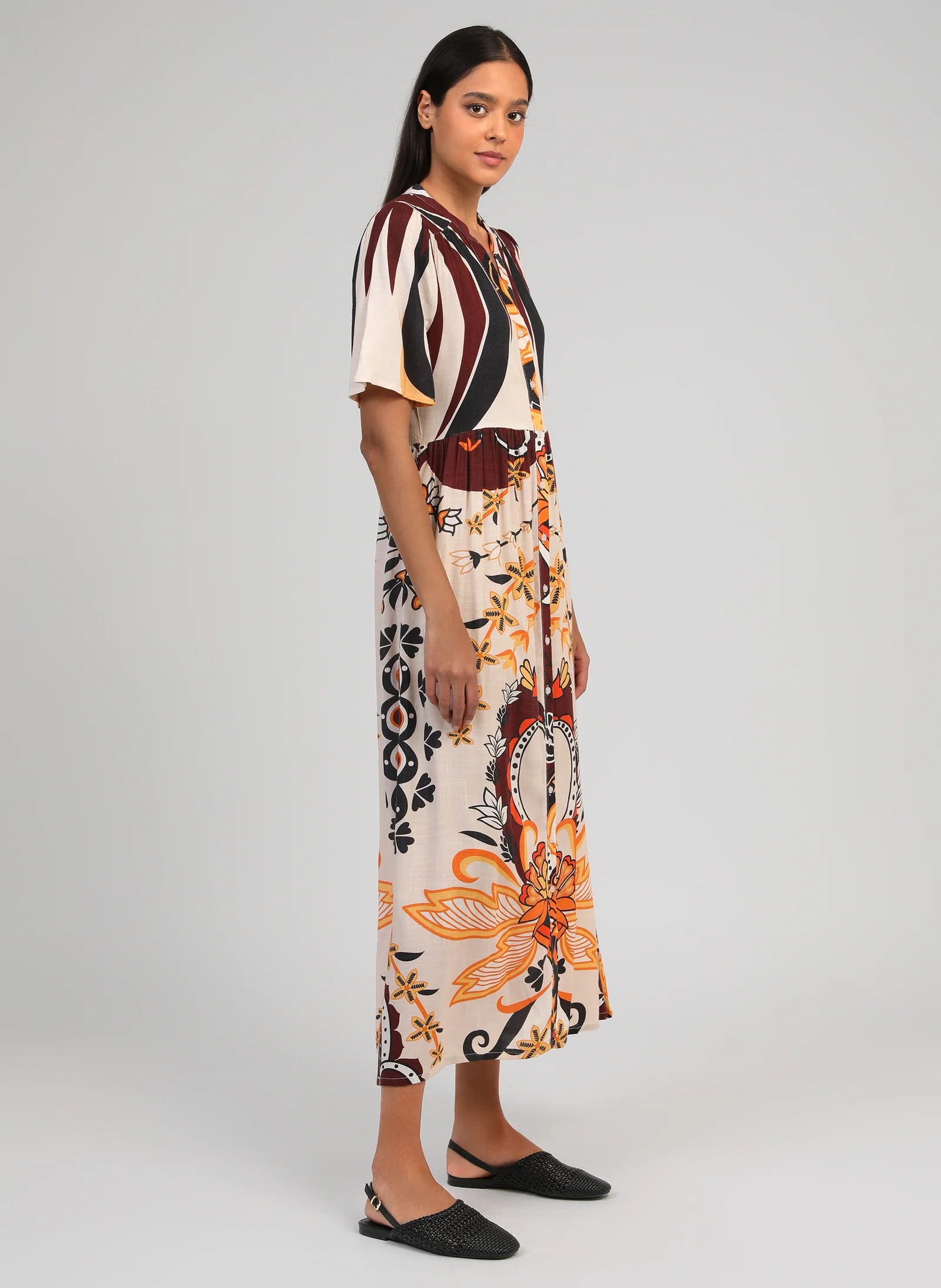 Woman wearing a patterned dress on a white background