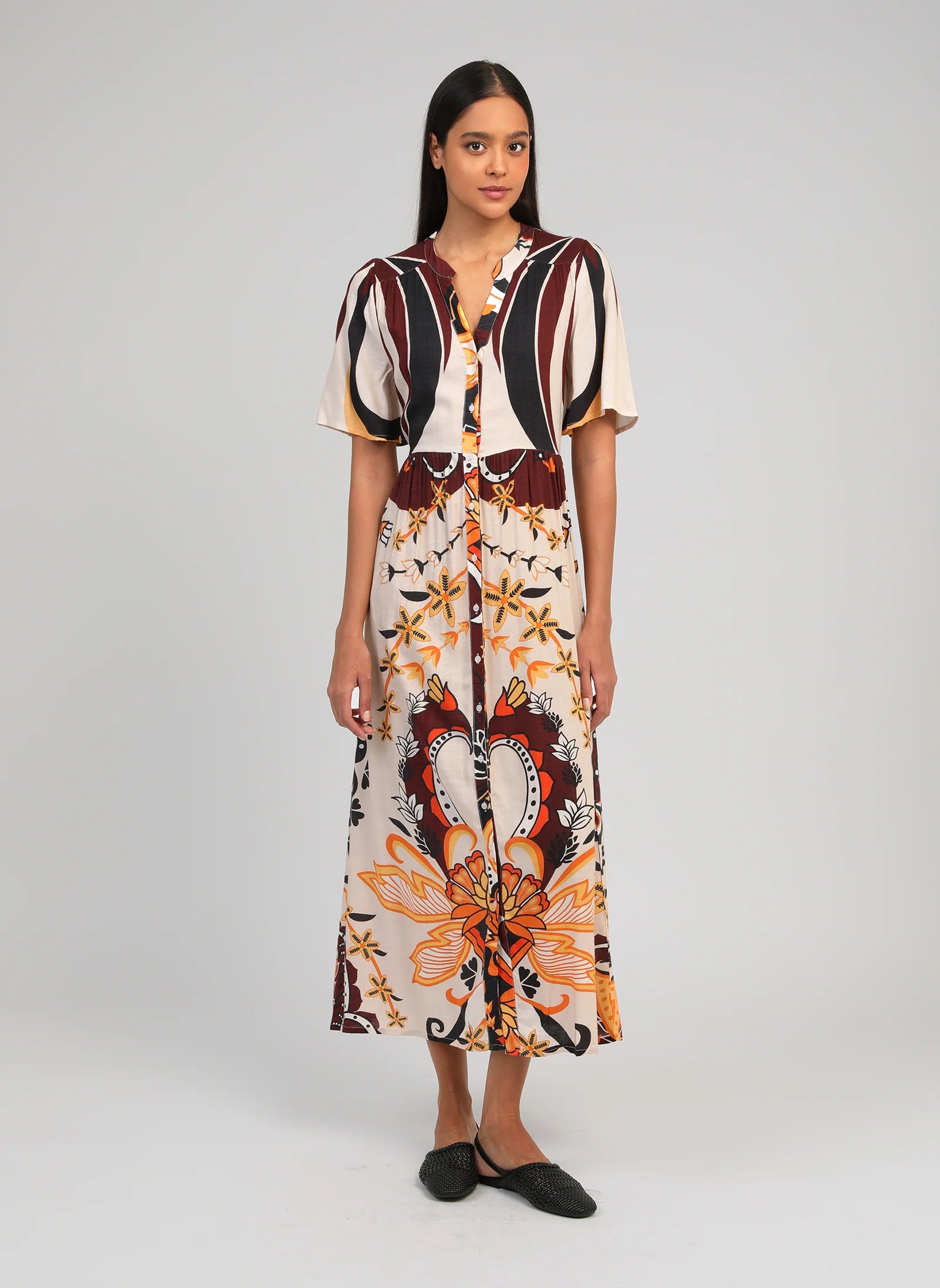 Woman wearing a patterned dress on a plain background