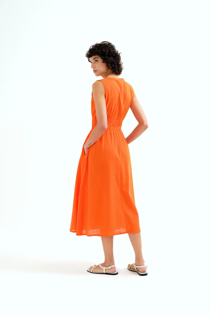 woman wearing an orange dress on a white background