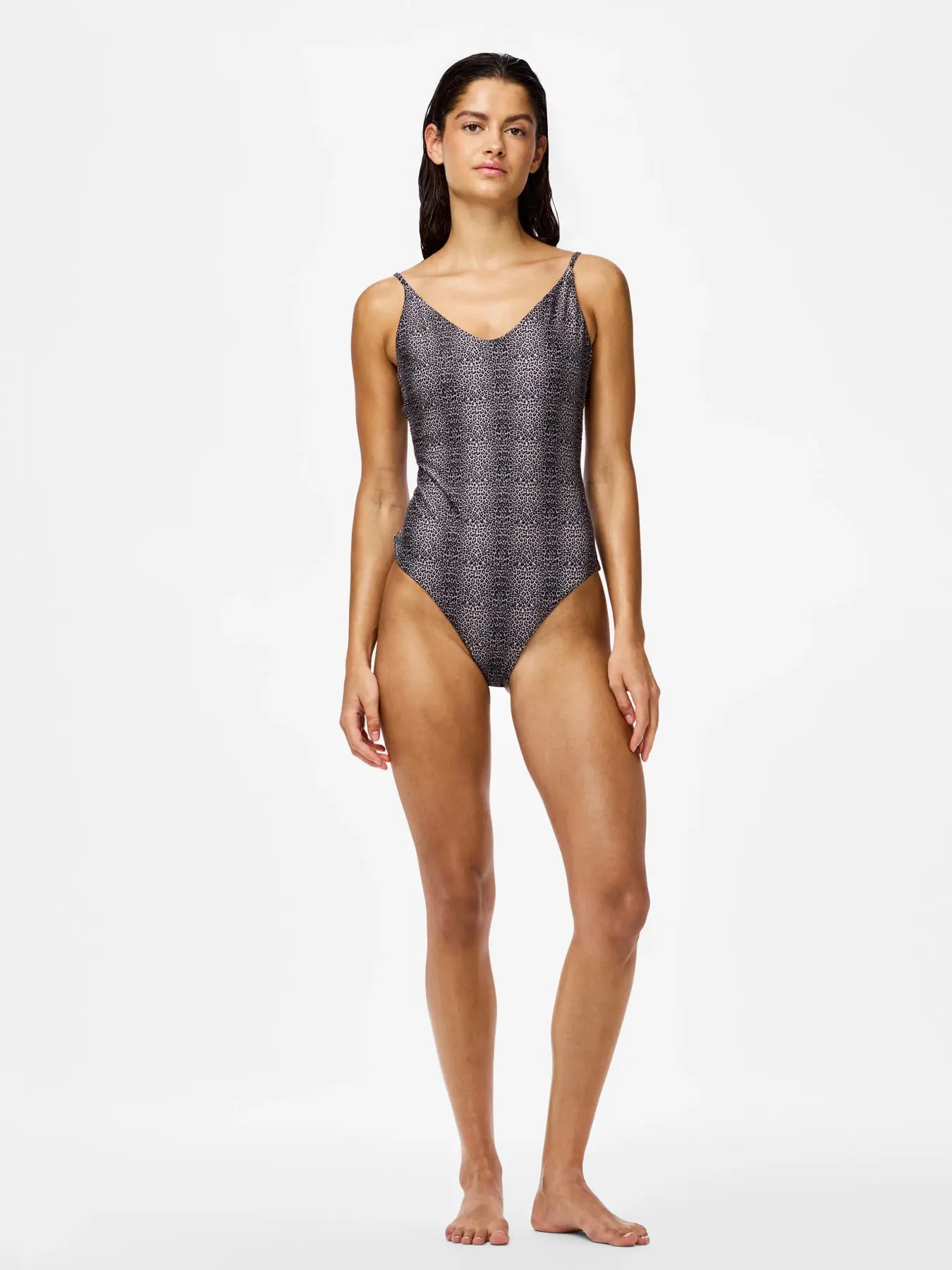 Woman wearing a patterned one-piece swimsuit on a white background