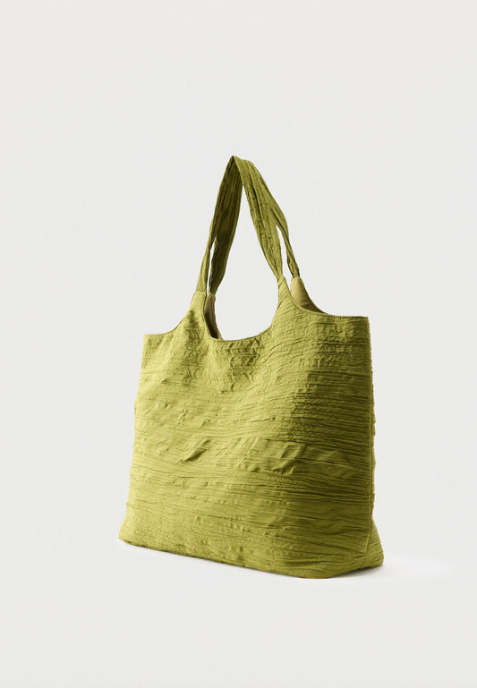 A textured olive green fabric tote bag with two shoulder straps, shown from a three-quarter angle against a light gray background.