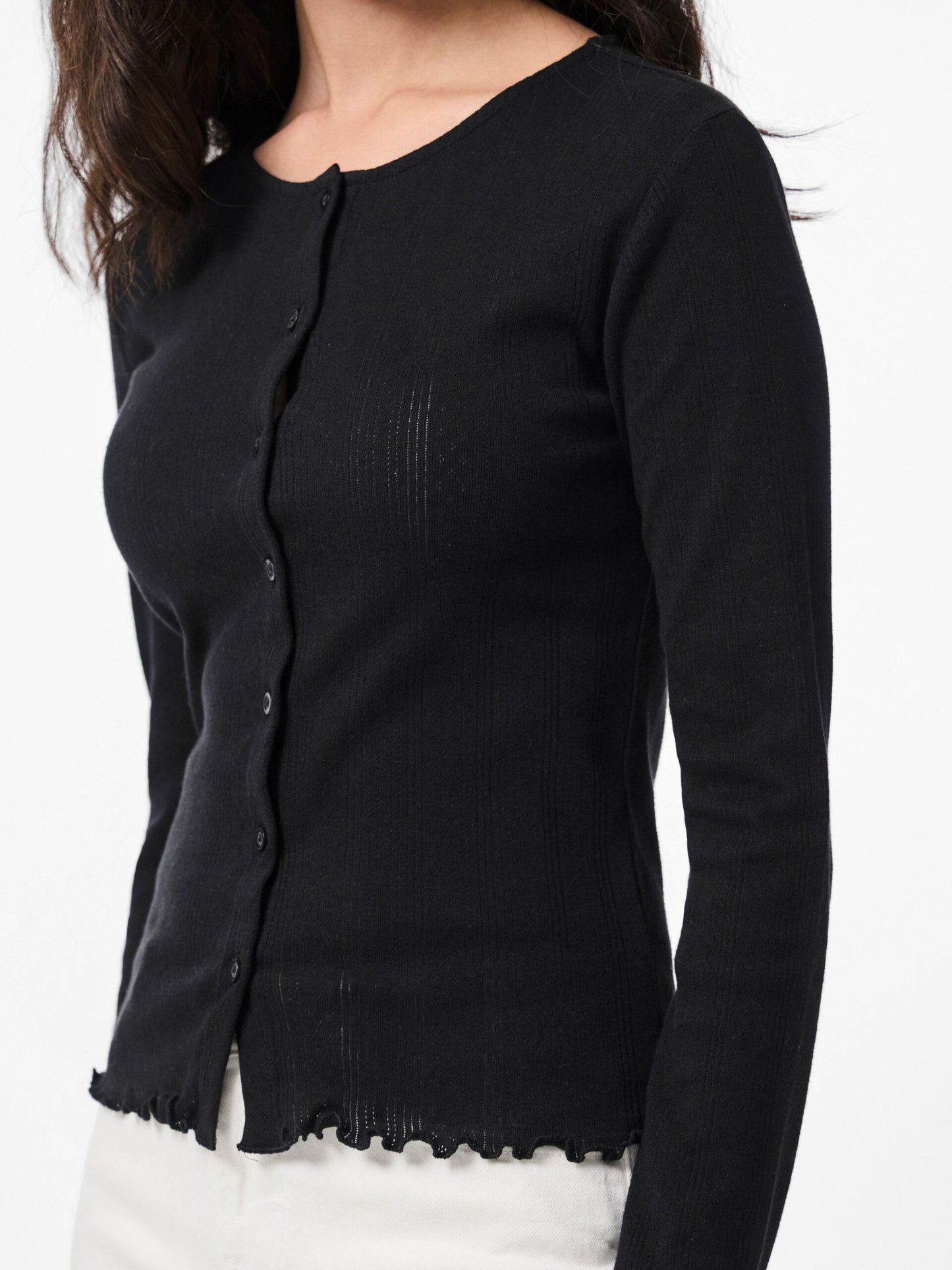Black cardigan worn by a person on a white background