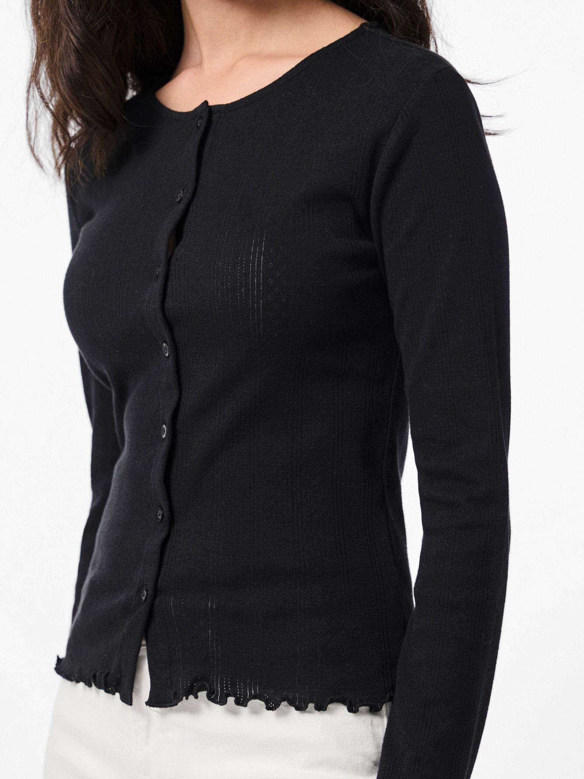 Black cardigan worn by a person on a white background