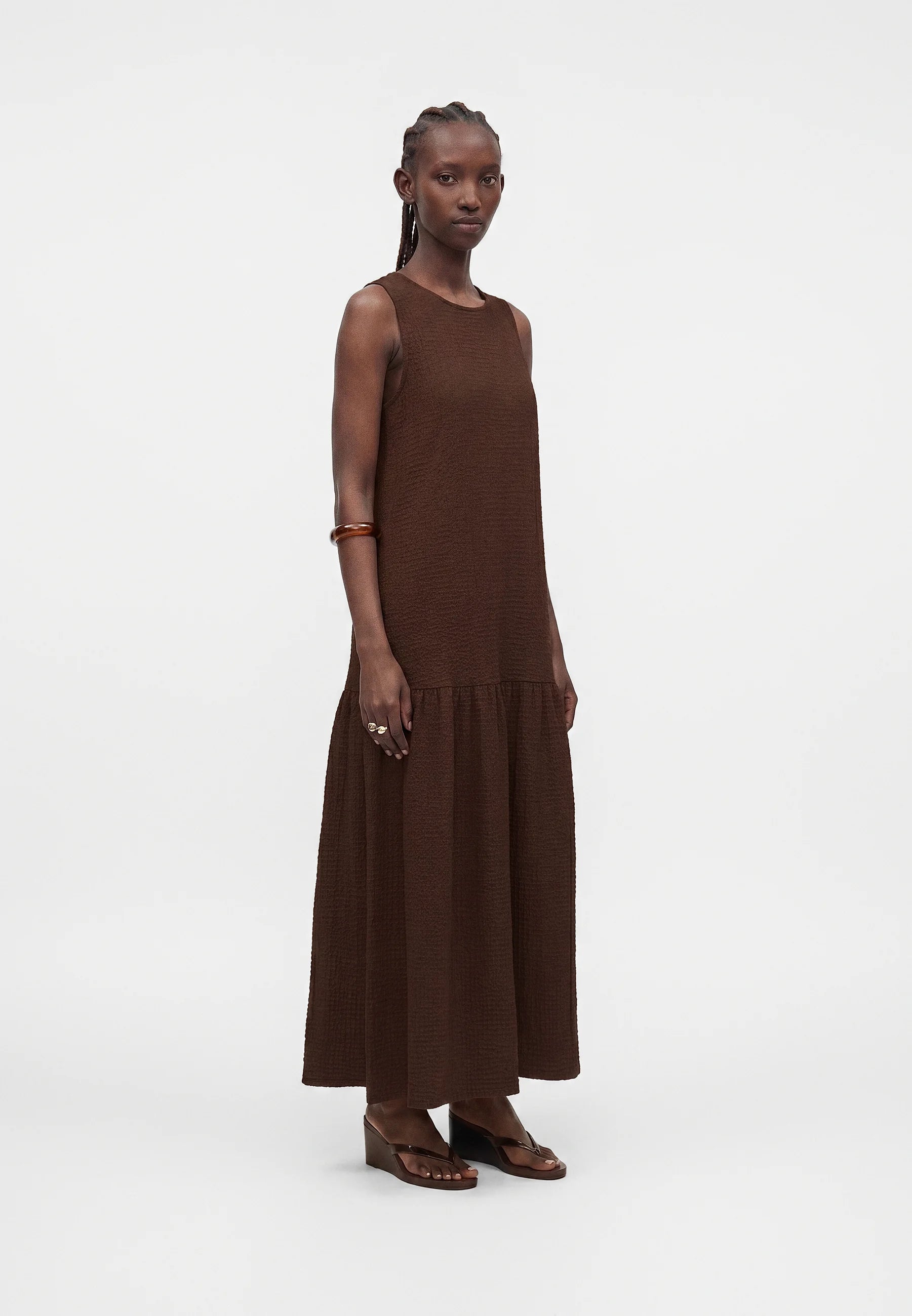 Woman wearing a brown dress on a white background