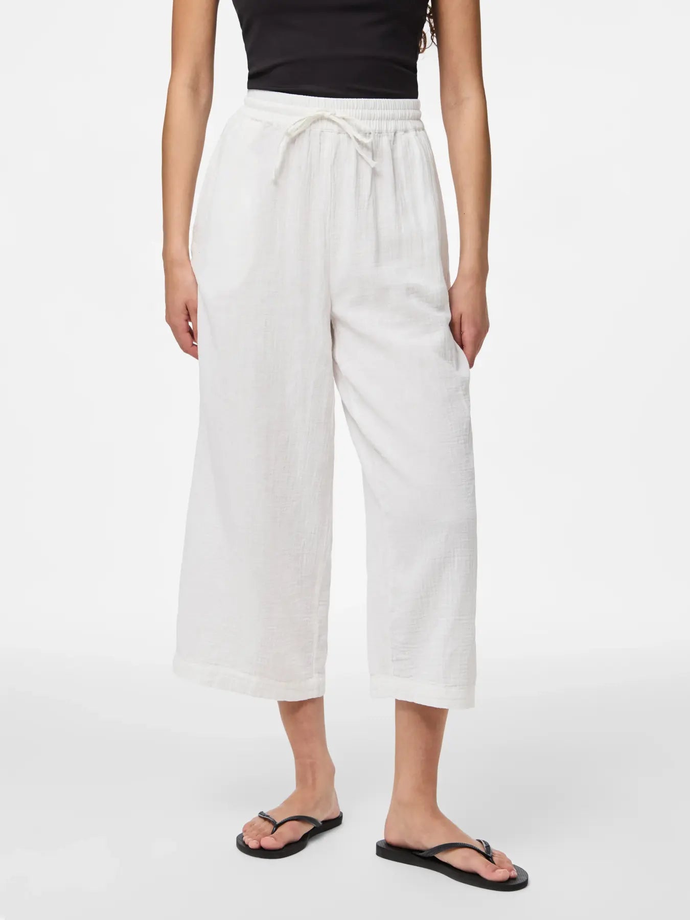 Person wearing white pants on a plain background