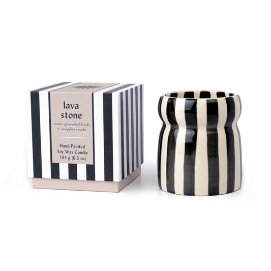 Black and white striped candle with packaging on a white background