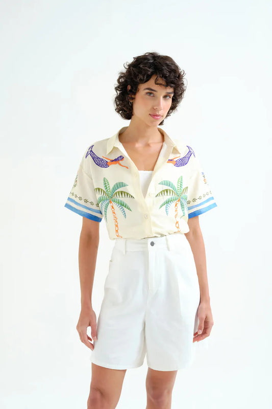 woman wearing shirt with mermaids and palm trees on white background