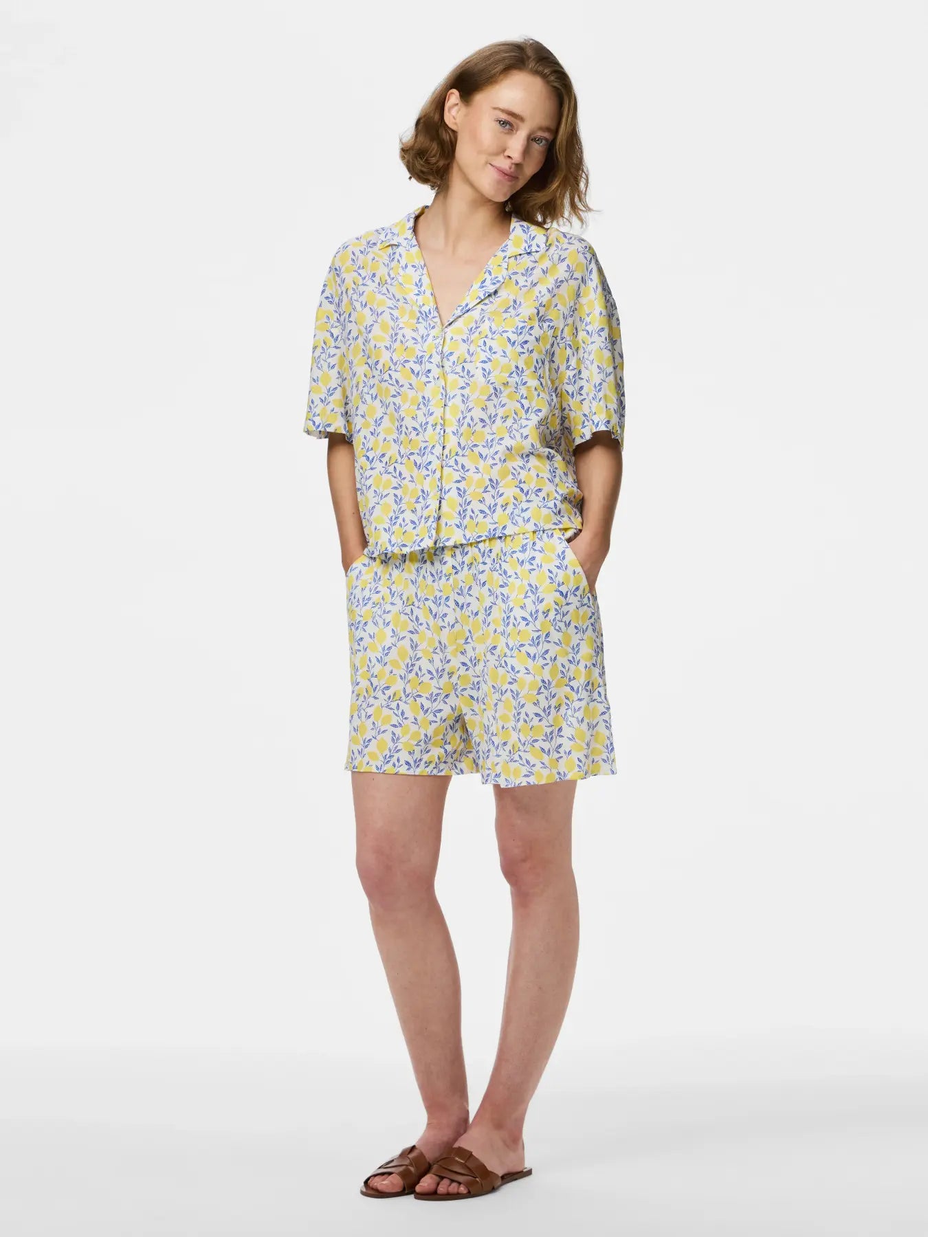 Woman wearing a floral pajama set on a white background