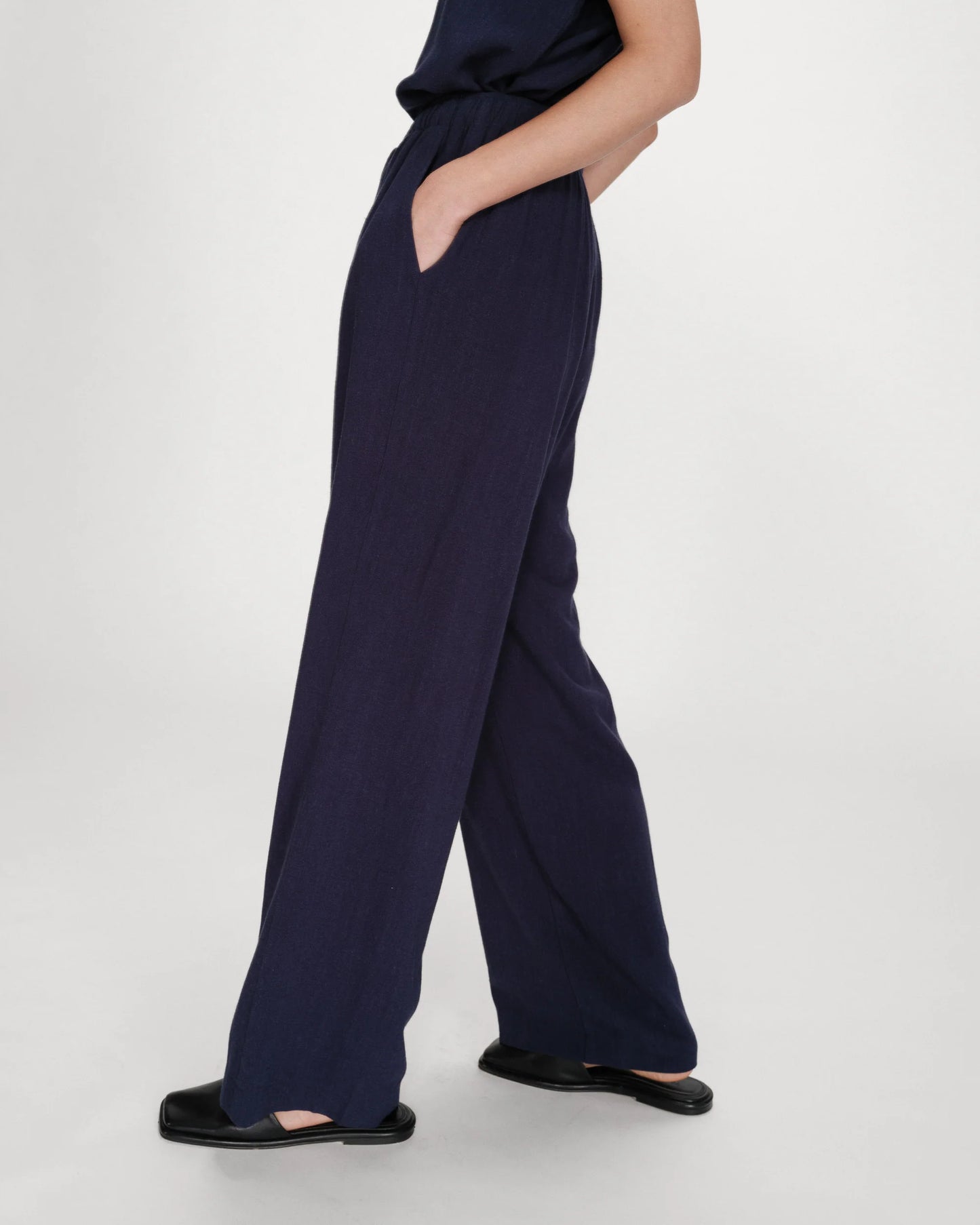Navy blue wide-leg pants worn by a person on a white background