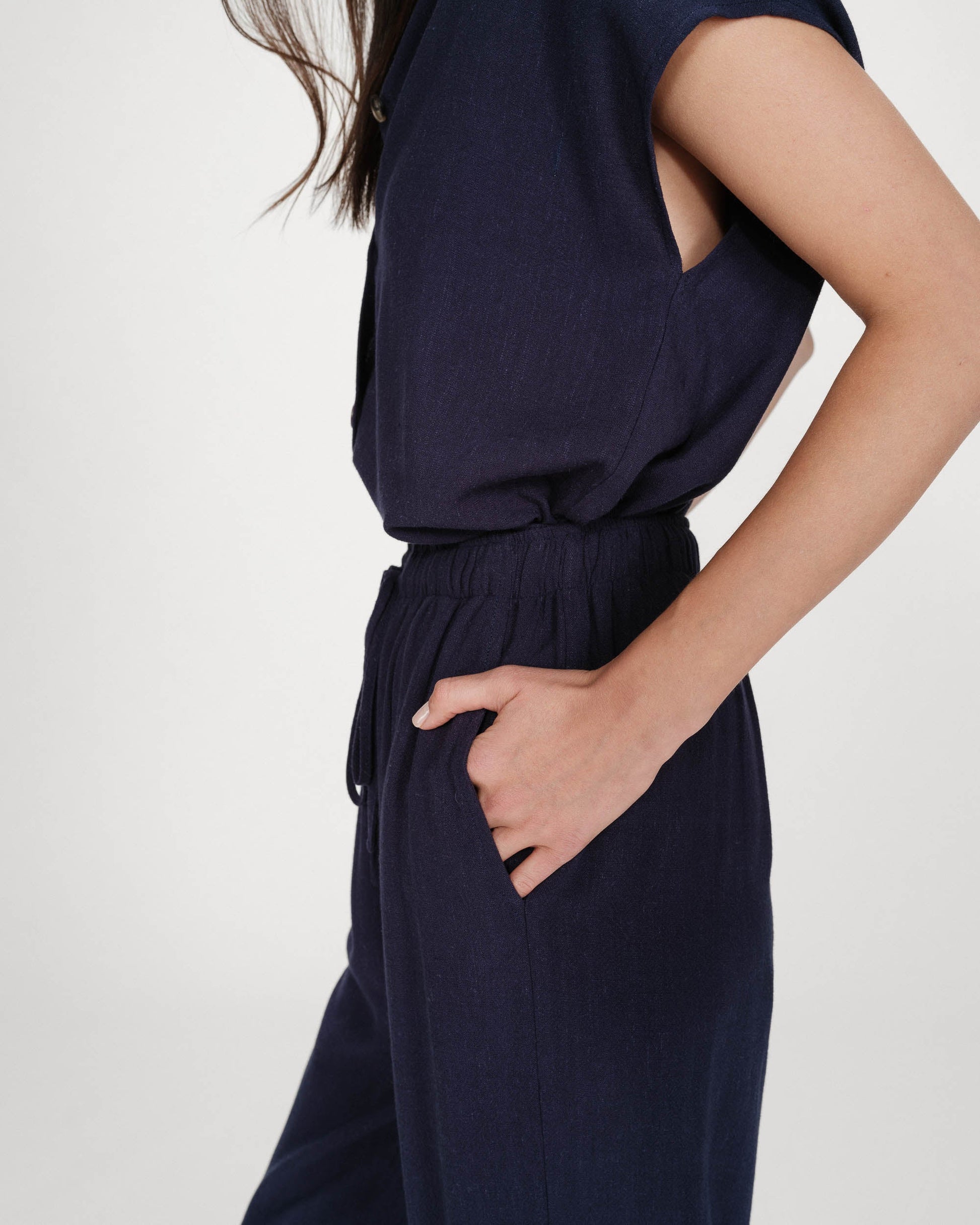 Navy blue jumpsuit worn by a person on a white background