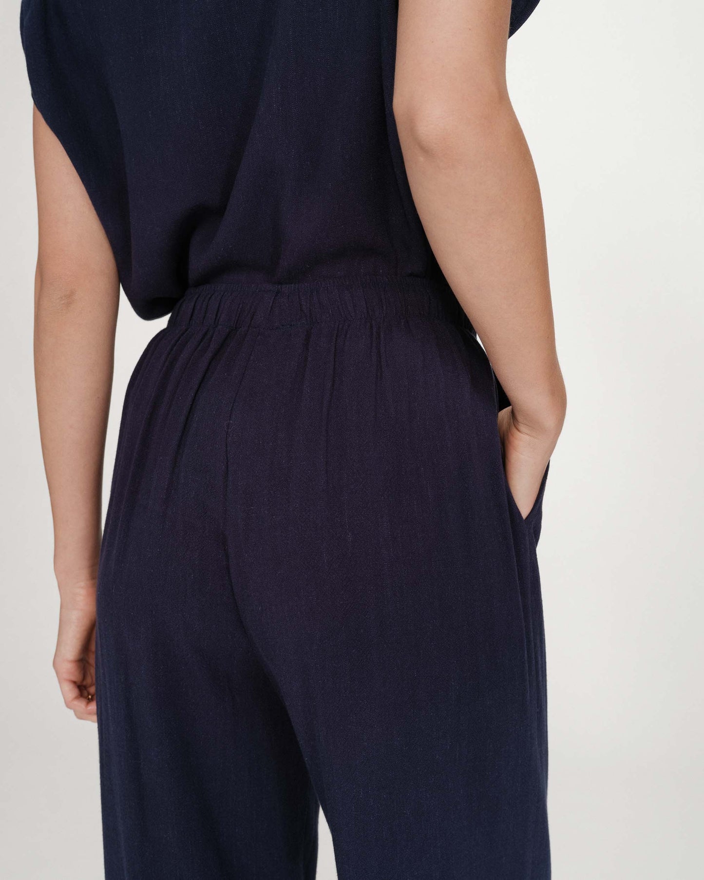 Navy blue jumpsuit worn by a person on a light gray background