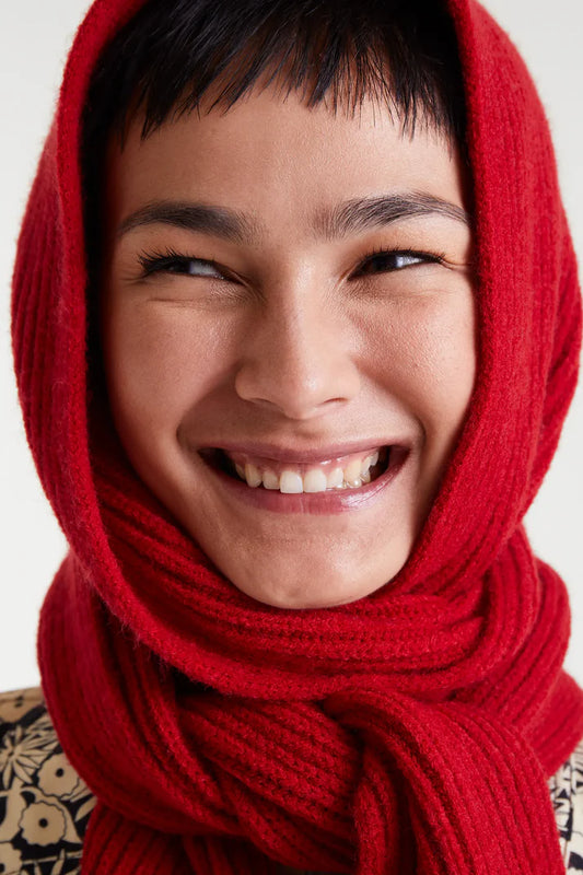 Person wearing a red scarf with a neutral background