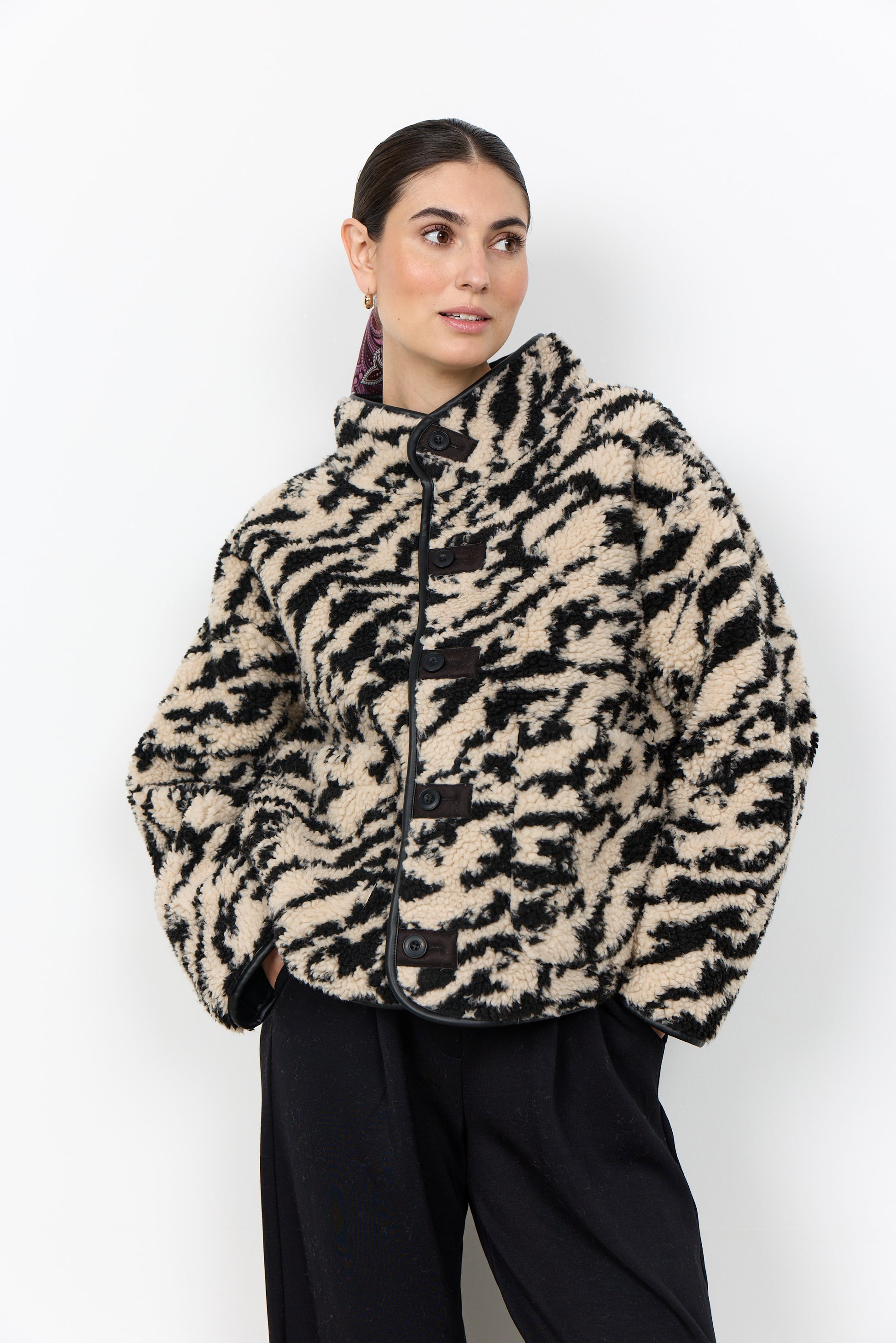 Person wearing a patterned jacket against a white background