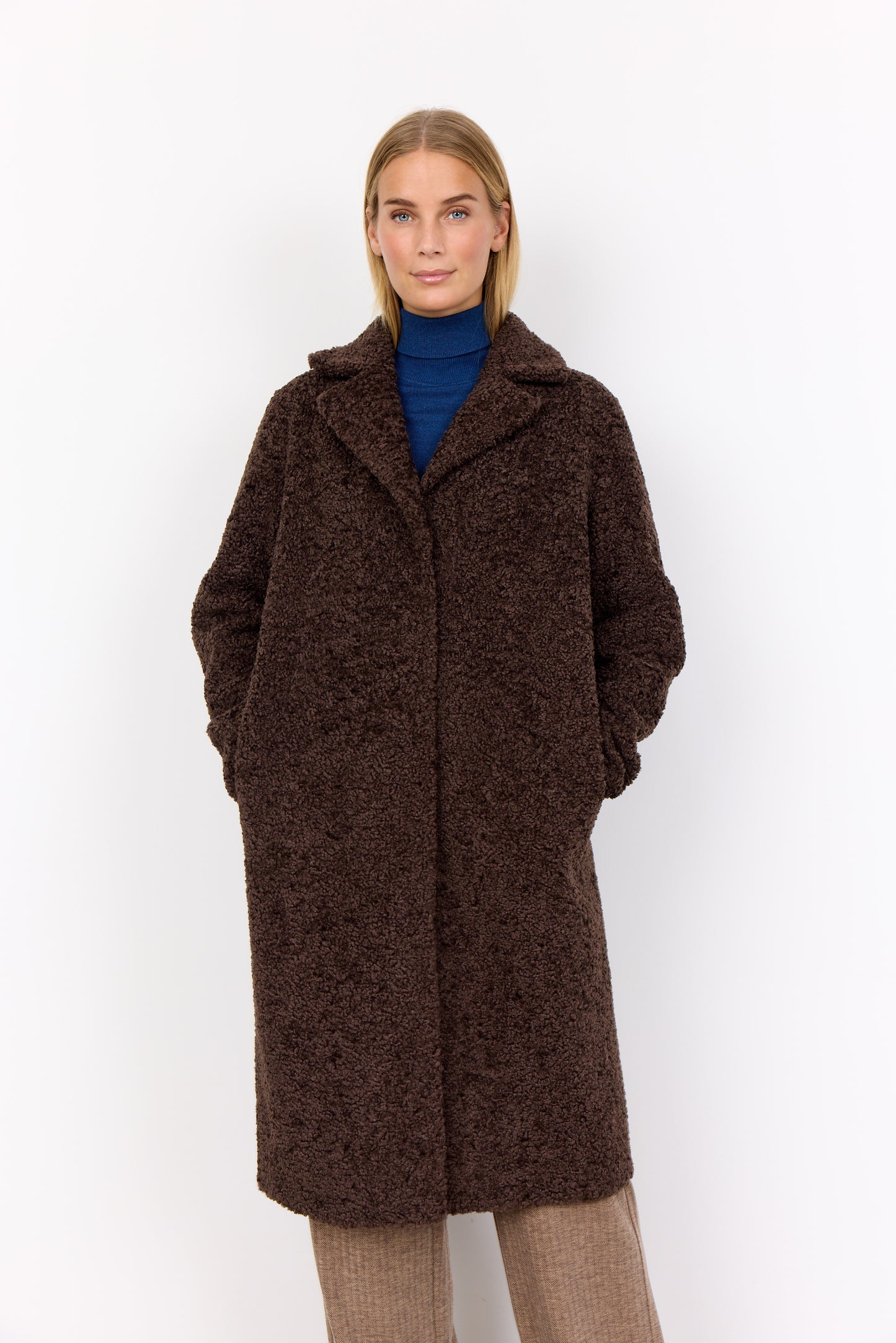 Woman wearing a brown coat on a white background