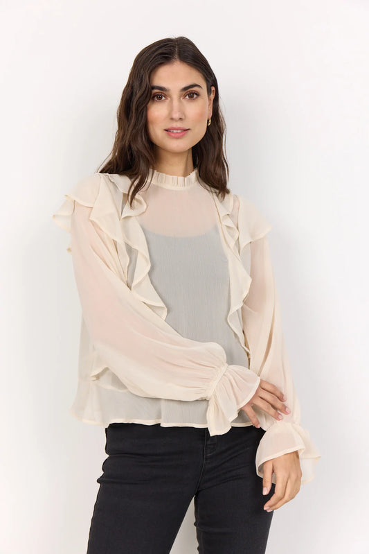 Woman wearing a cream blouse and black trousers with a white background