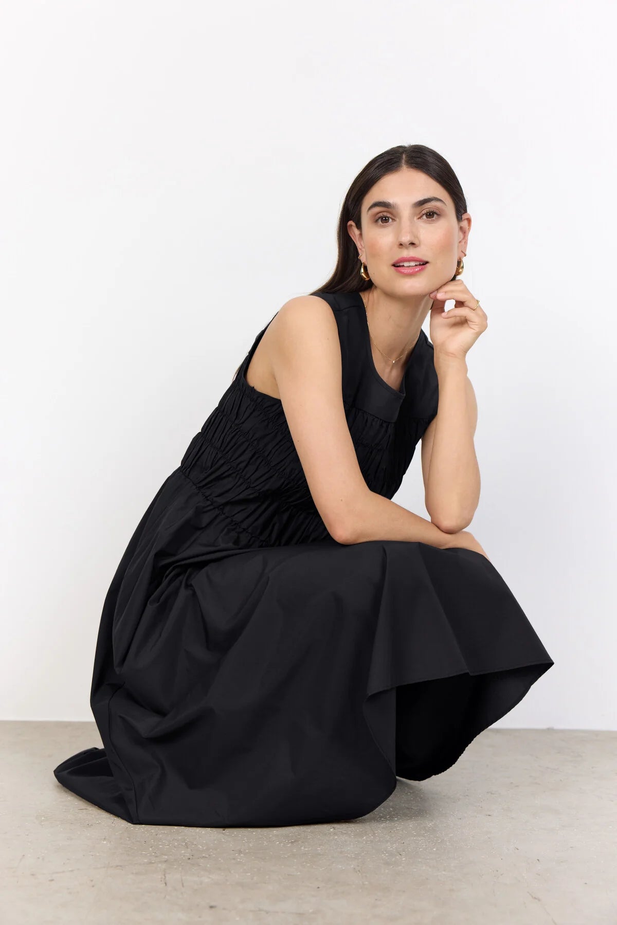 model in a black dress on a white background
