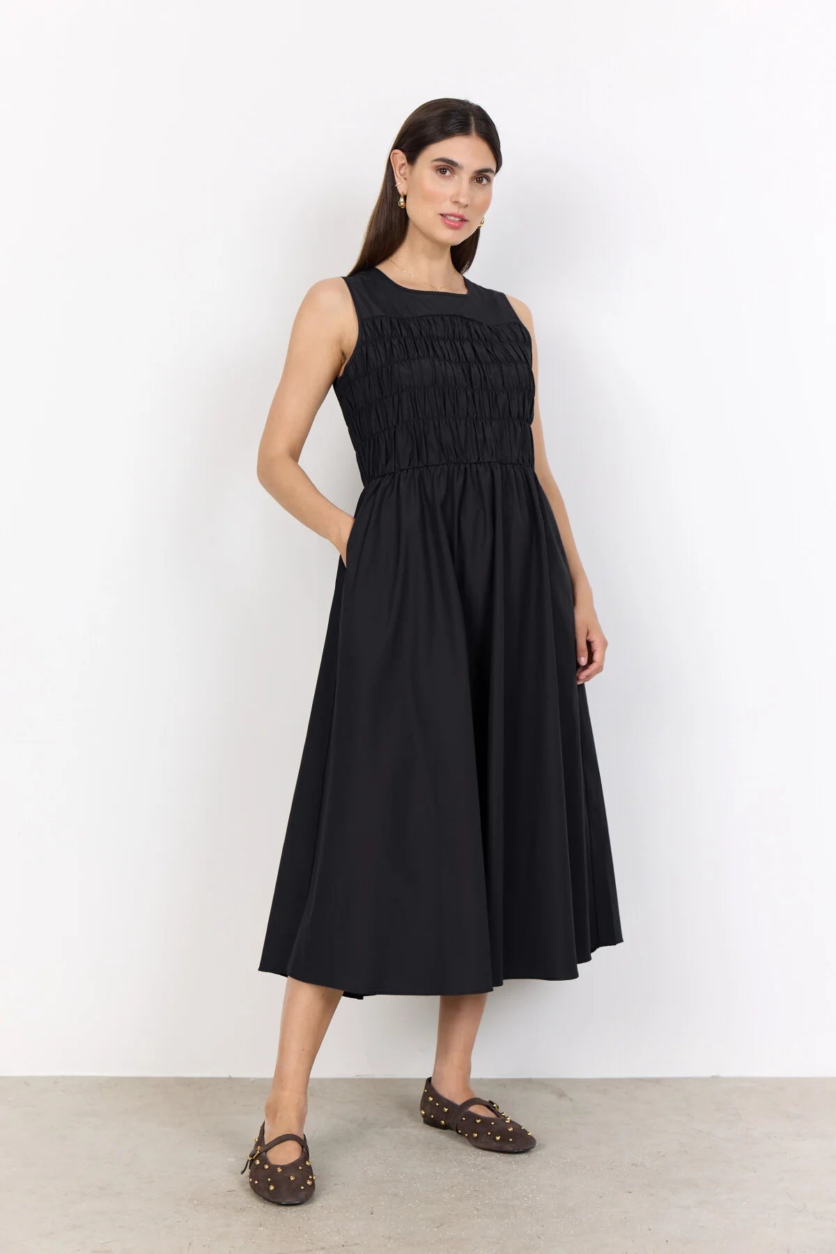 model in a black dress on a white background