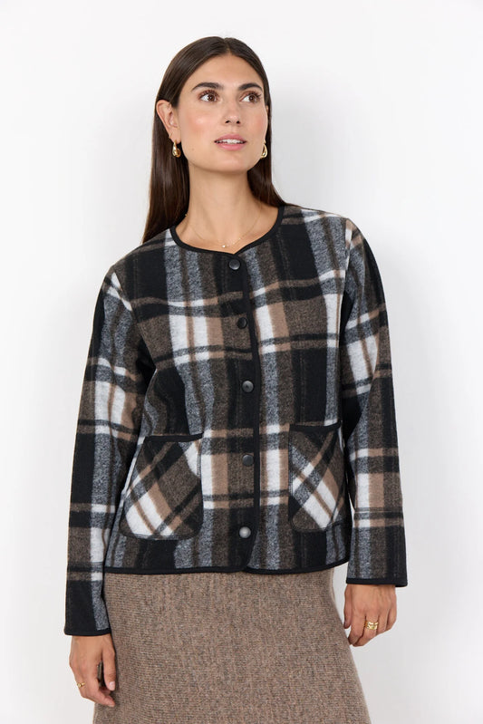 Woman wearing a plaid jacket against a white background