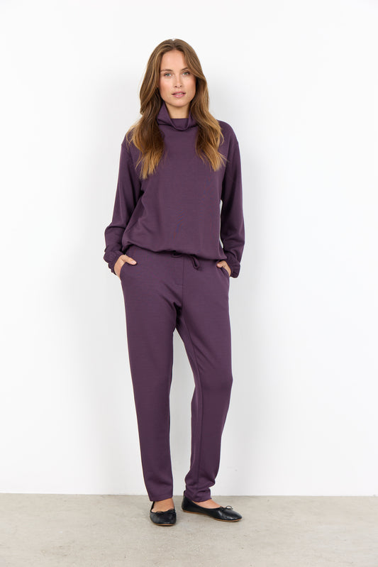 Woman wearing a purple outfit against a white background