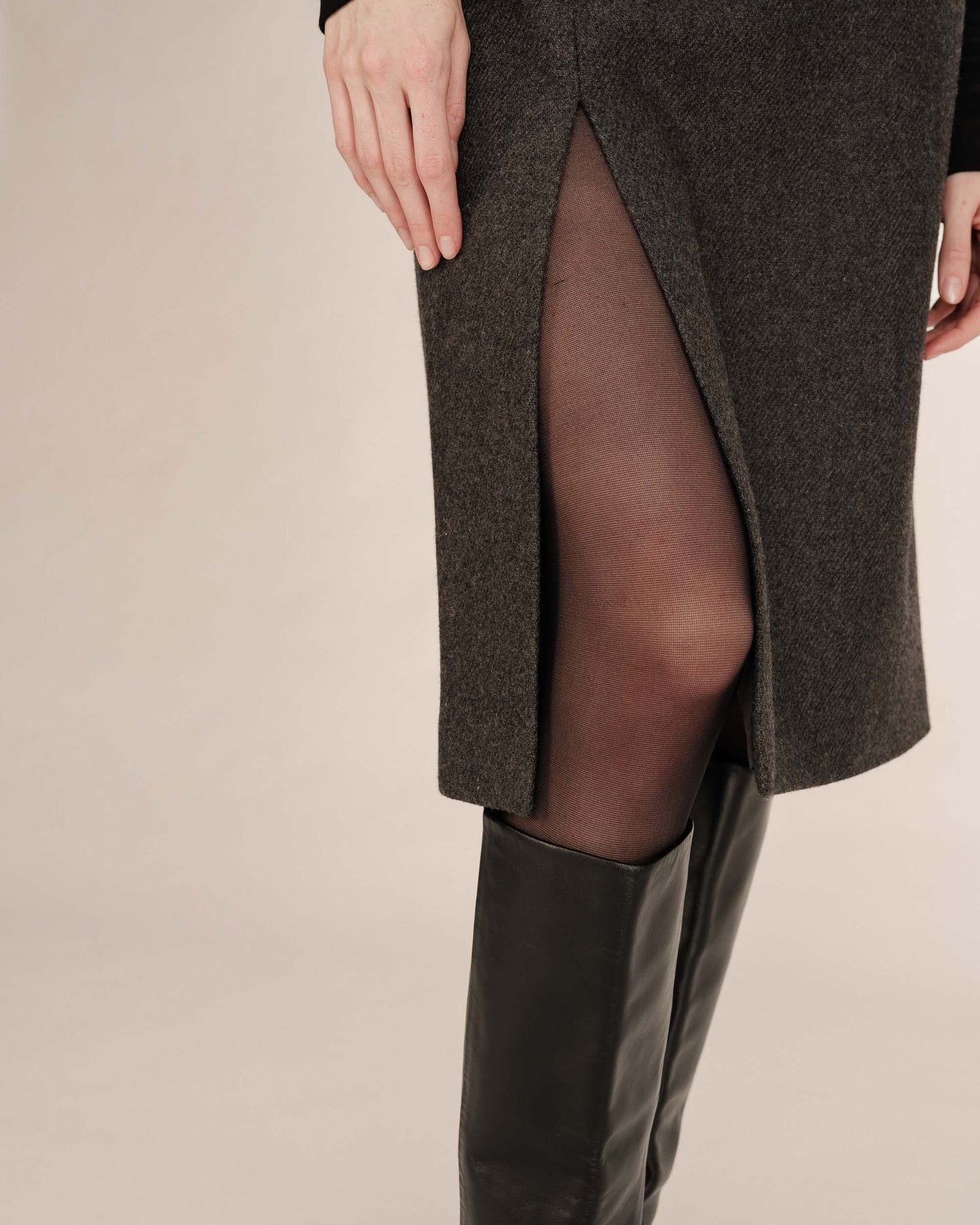 Brown knee-length coat with a high slit on a beige background