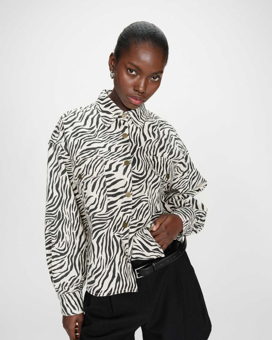 Person wearing a zebra print shirt on a white background