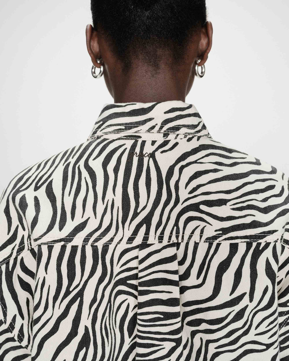 Person wearing a zebra print shirt with a plain background