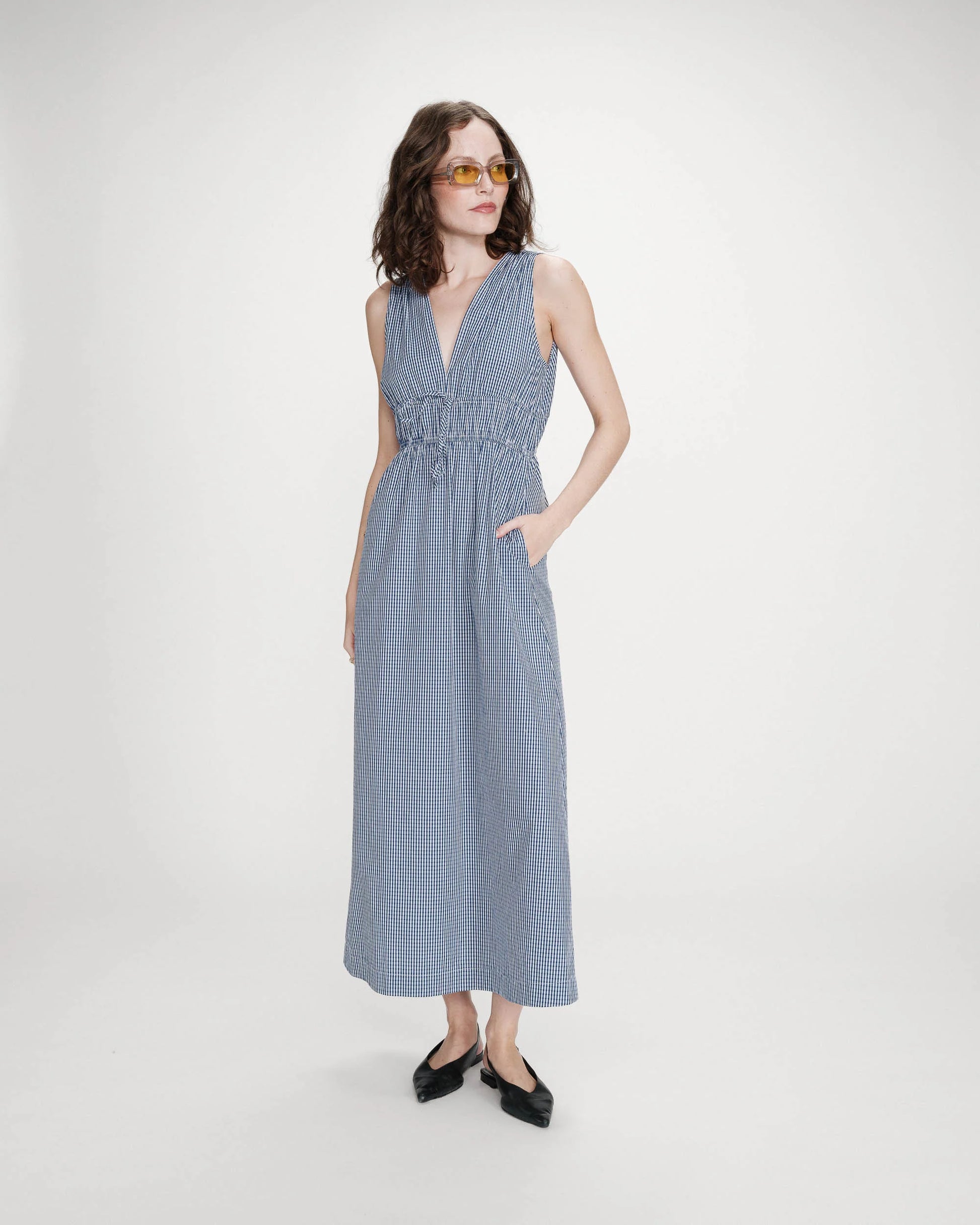 Woman wearing a blue checkered dress on a white background