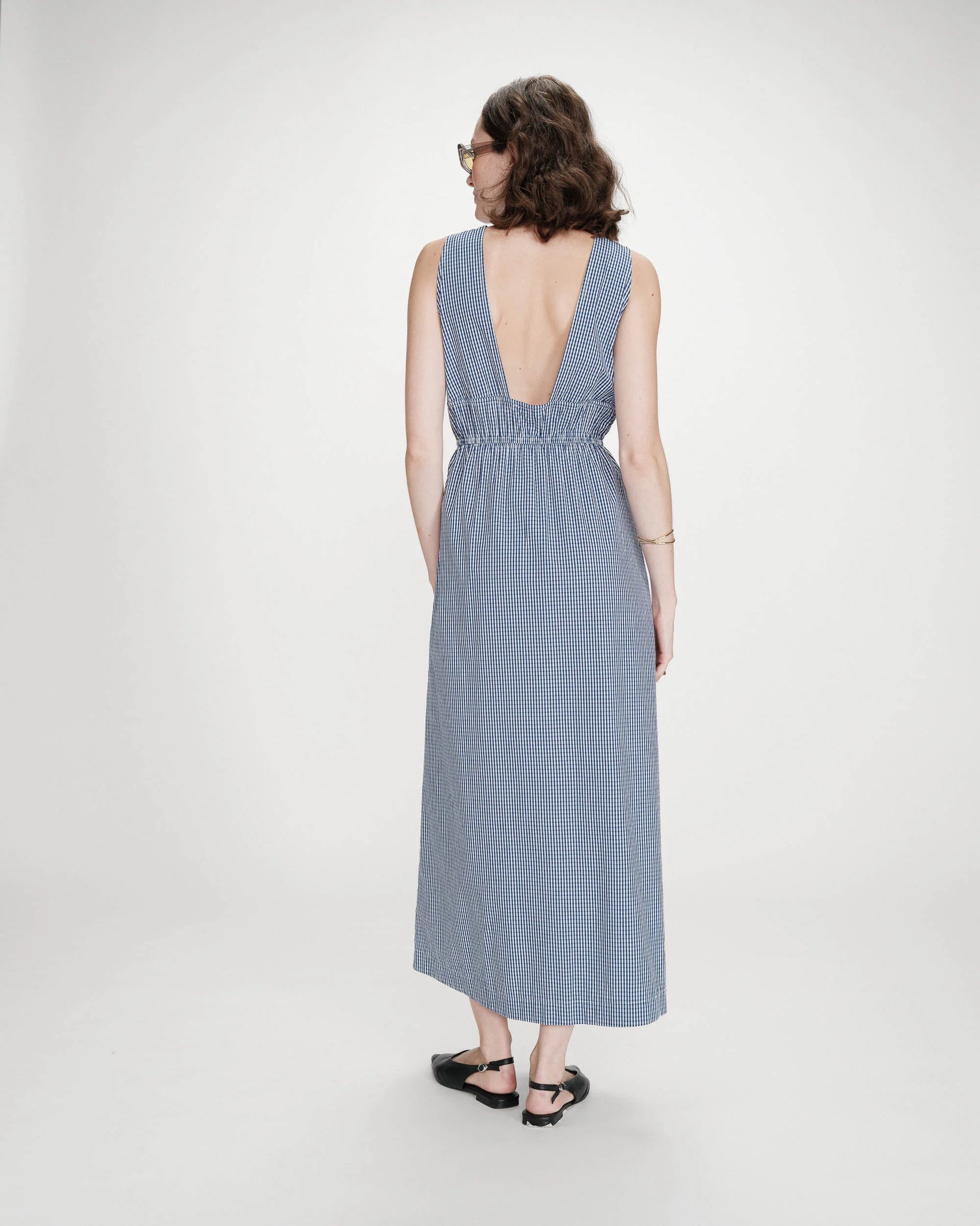 Woman wearing a blue striped dress on a white background