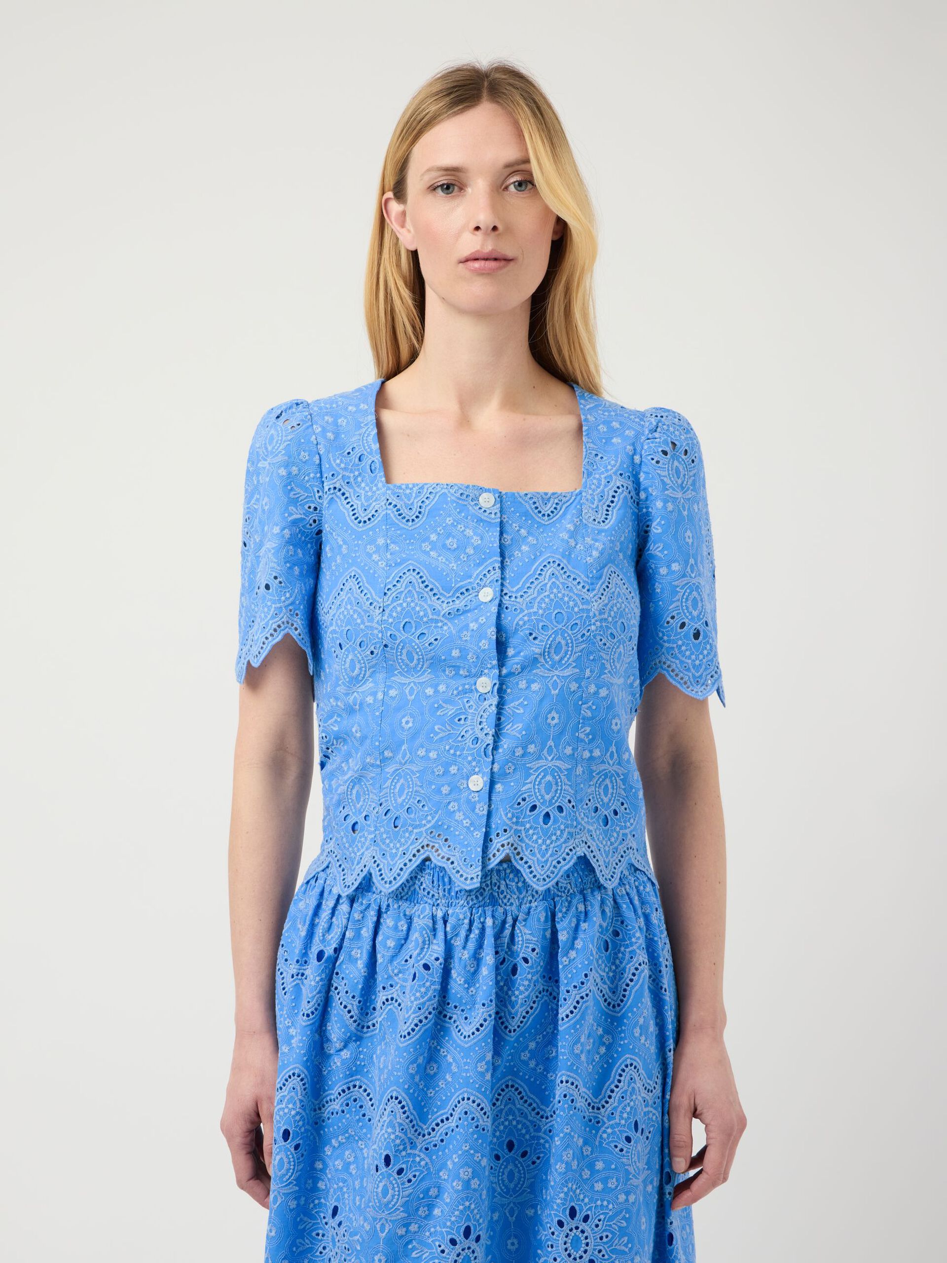 Woman wearing a blue patterned dress on a white background