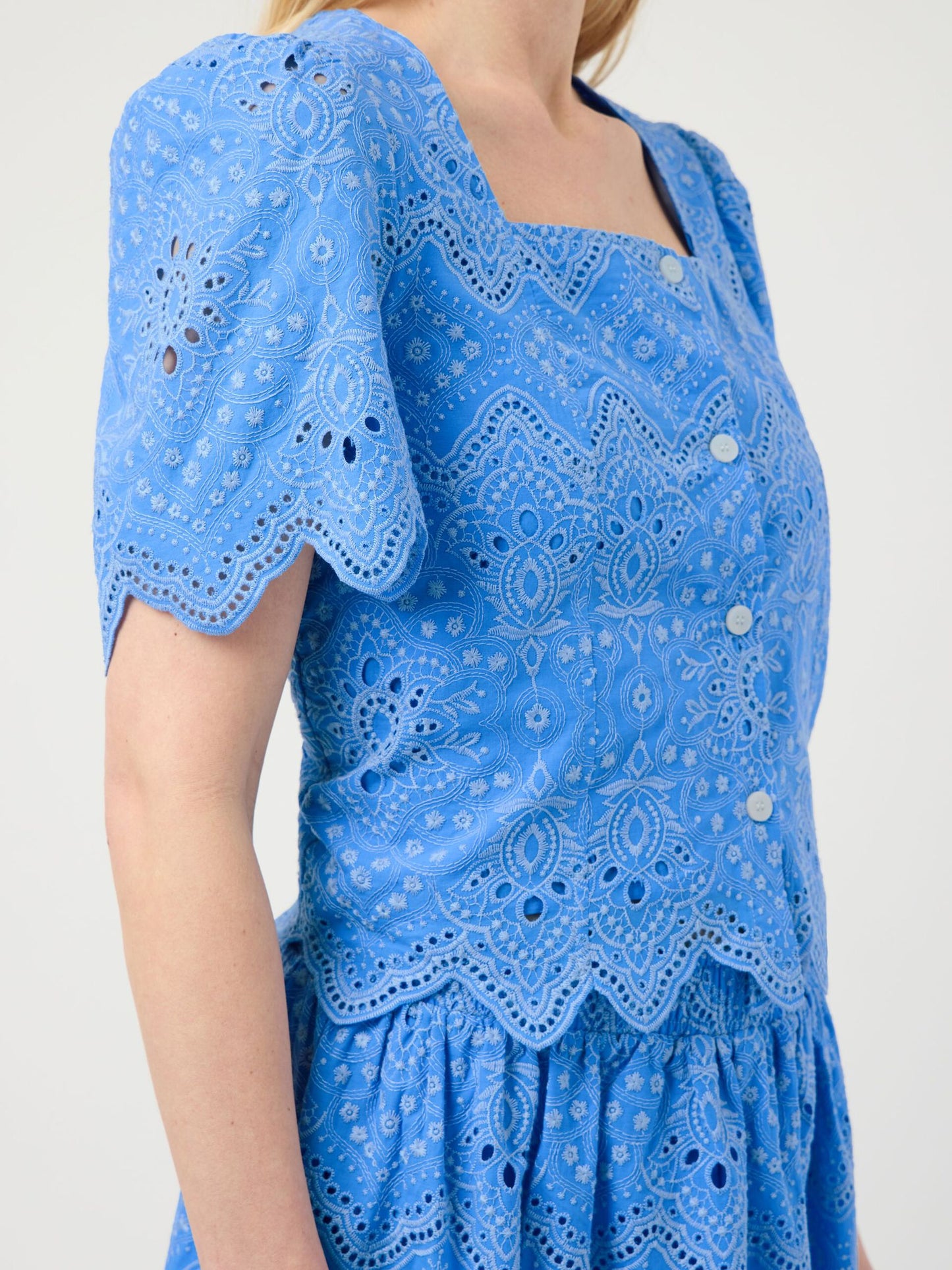 Blue embroidered dress on a white background