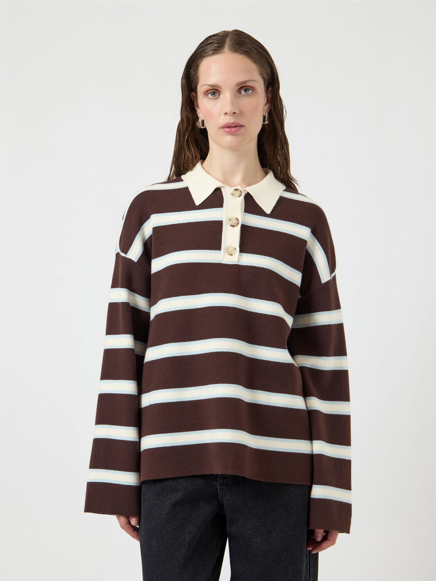 Woman wearing a brown and white striped sweater on a white background
