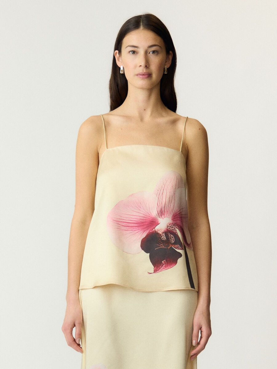 Person wearing a Pale yellow strappy top with pink floral print on a white background