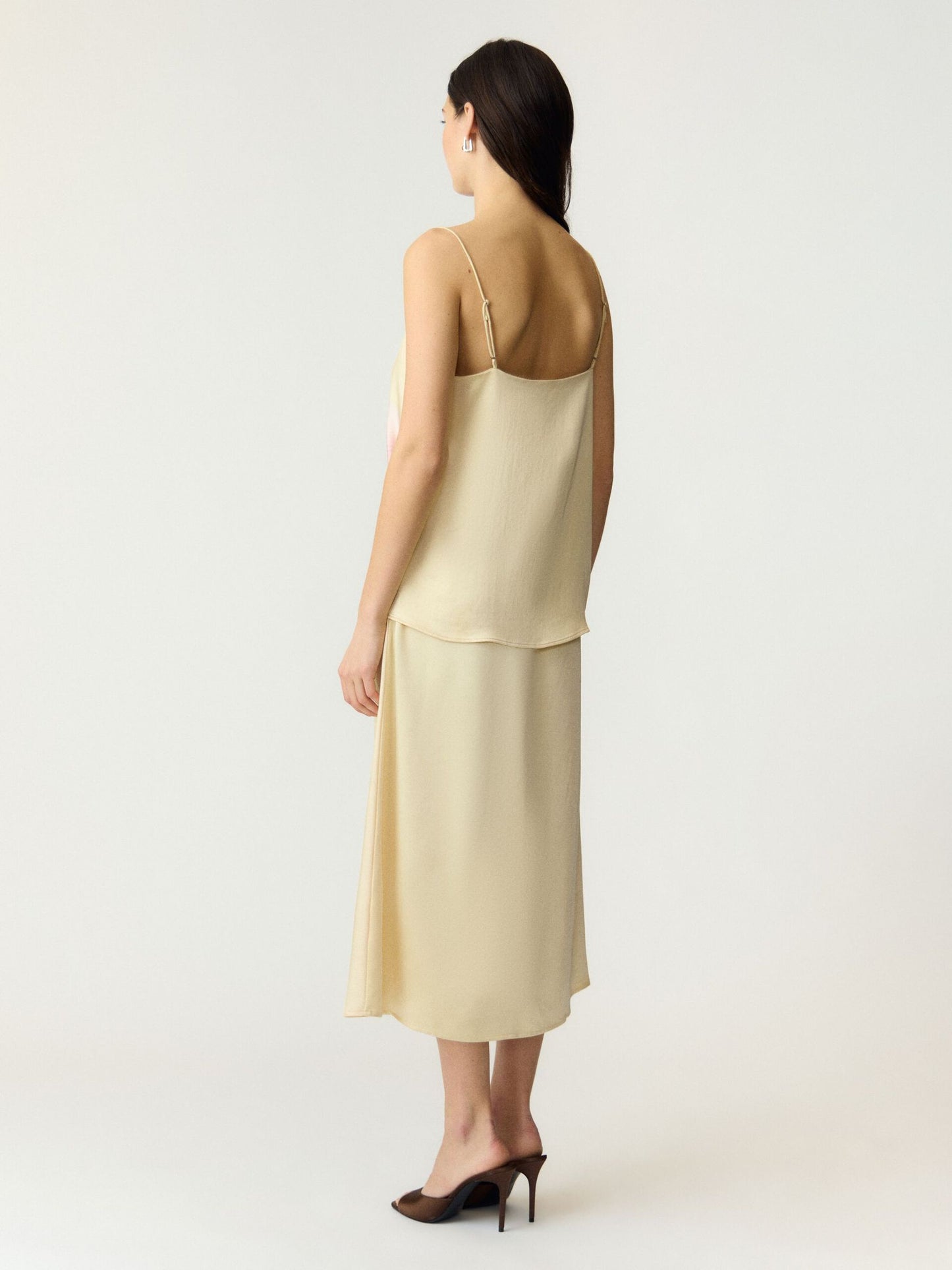 Pale yellow strappy top and skirt on a white background