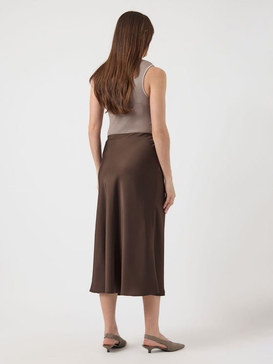 Woman wearing a brown skirt and beige top on a white background