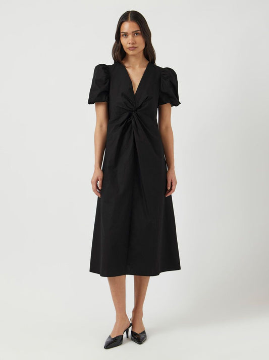 Woman wearing a black dress with puff sleeves on a white background