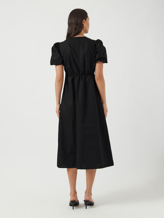 Woman wearing a black dress with puff sleeves on a white background