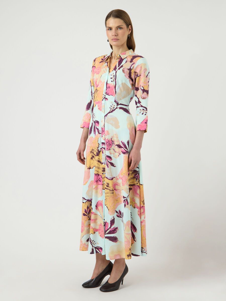 Woman wearing a colorful floral dress on a white background