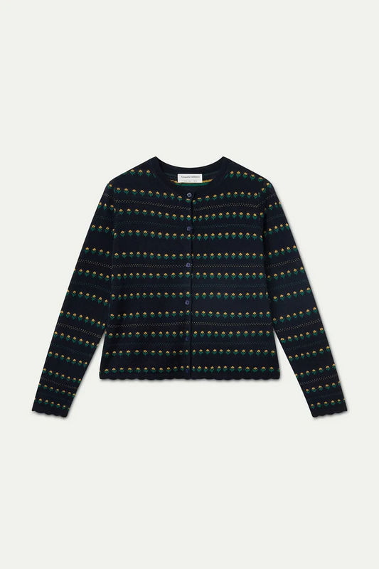 A long-sleeve knit cardigan with a dark navy base and a repeating horizontal pattern of small green, yellow, and orange motifs, laid flat against a light gray background.