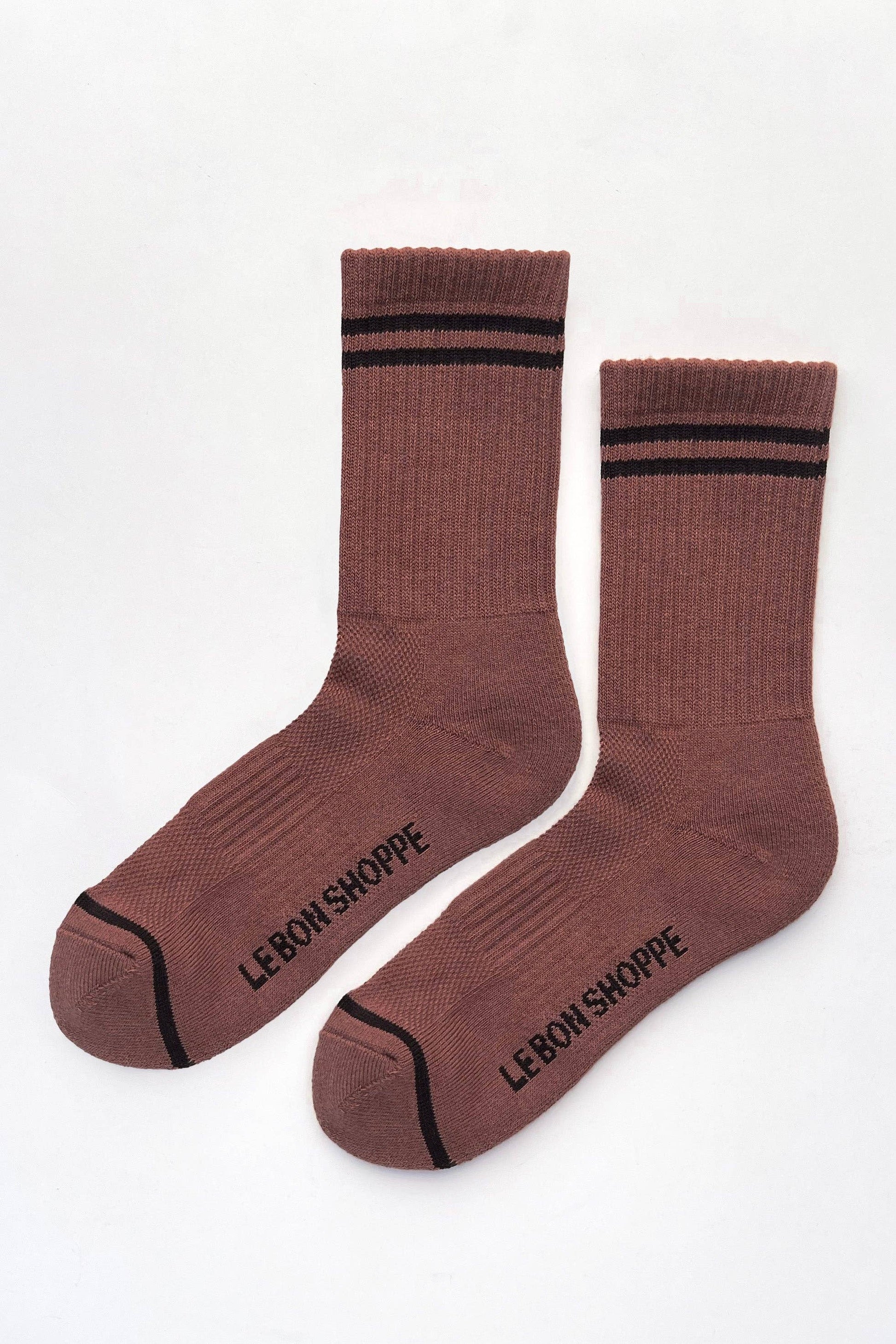 A pair of brown crew socks with black stripes at the ribbed cuffs, black toe caps, and black text reading 'LEBON-SHOPPE' printed on the soles, displayed on a clean white background.
