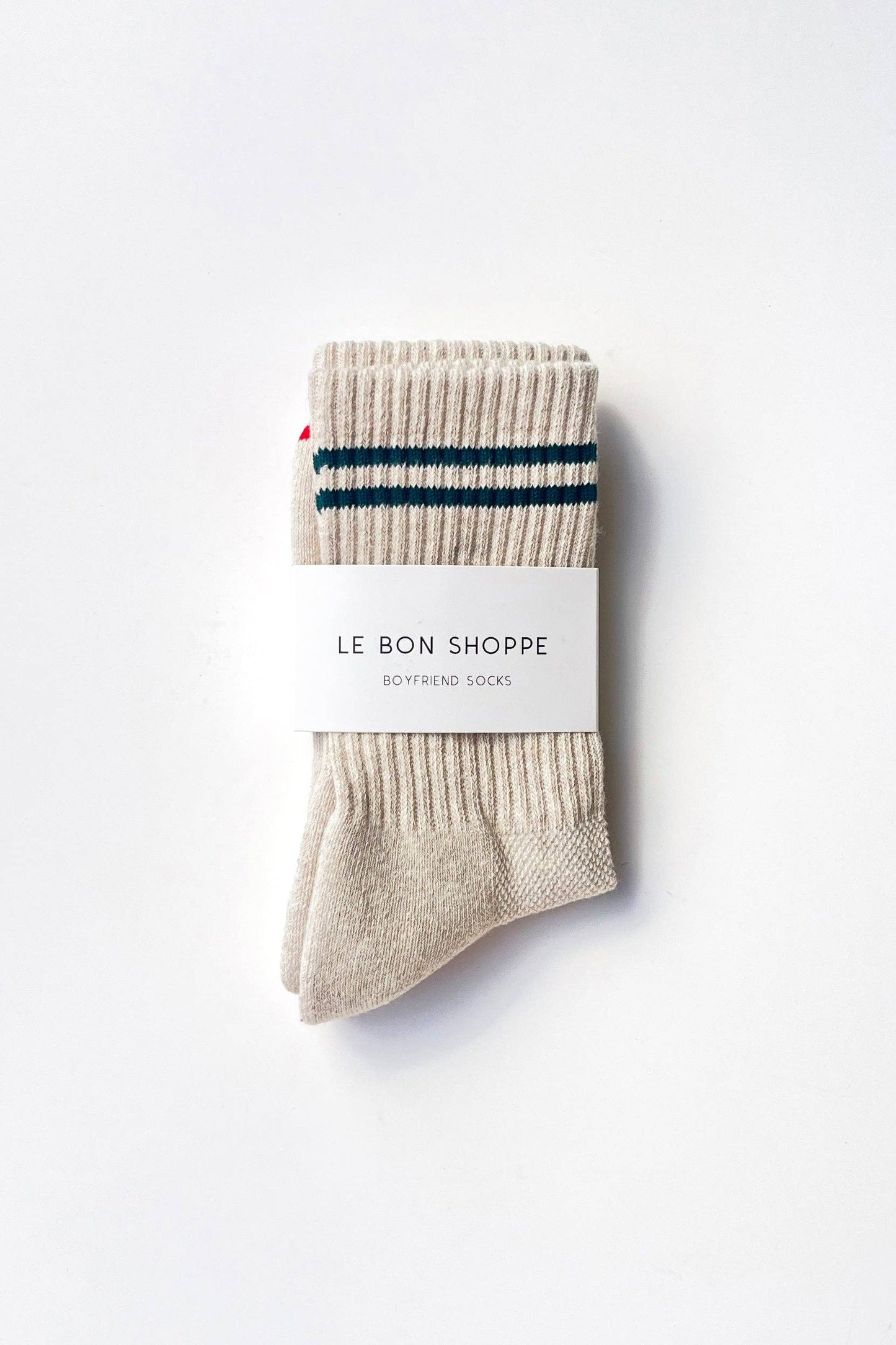 Pair of beige socks with a blue stripe on a white background, featuring 'Le Bon Shoppe' branding.