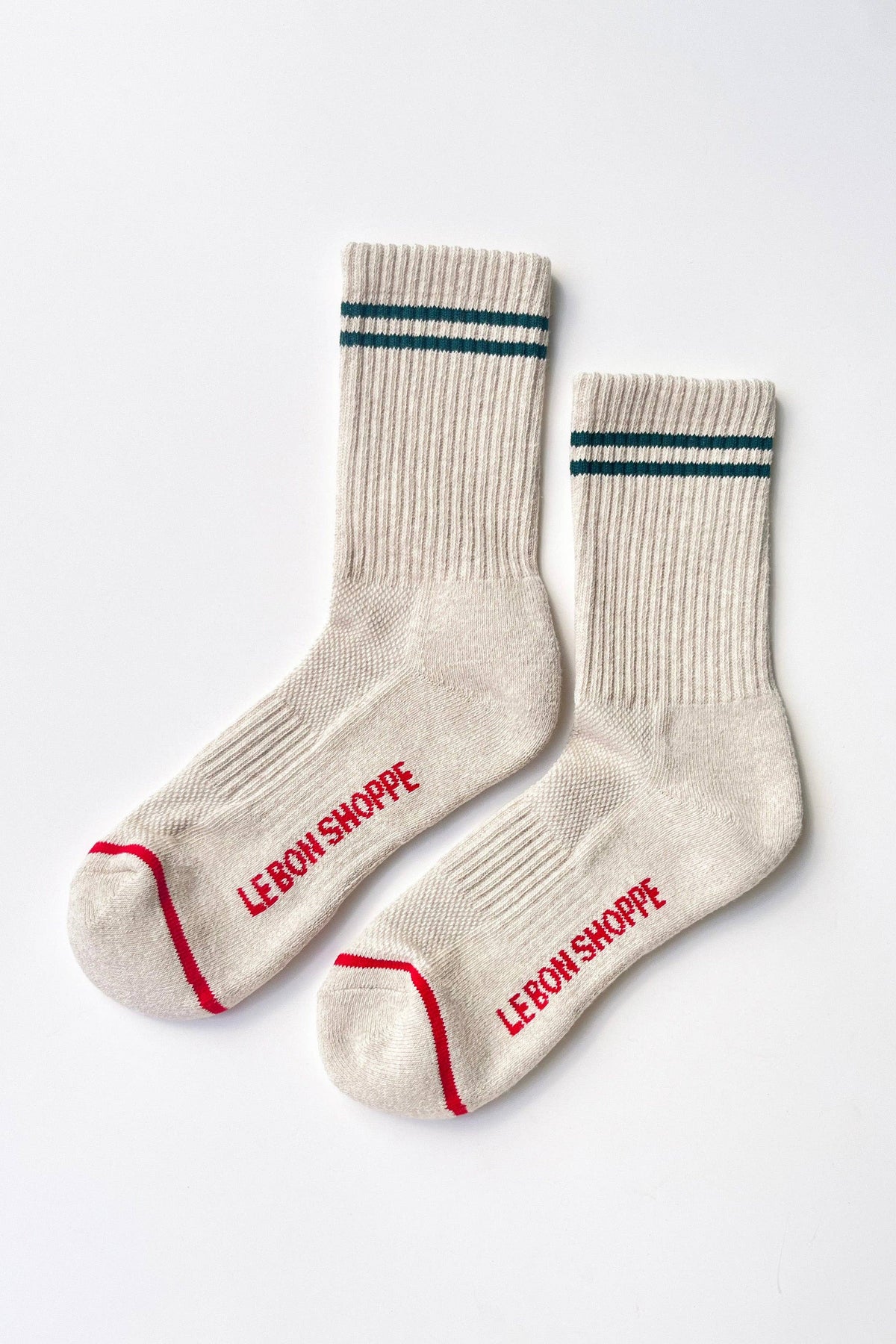 Pair of beige socks with red text on a white background